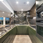 Kitchen with marble walls and benchtops and cabinets painted in Resene Midnight Moss